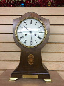 Restored balloon-shaped mantel clock in polished wood
