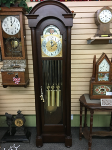 1915 Herschede nine-tube tubular grandfather clock in a dark arched case, standing in the showroom