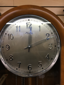 Restored wall clock with a round silvered dial