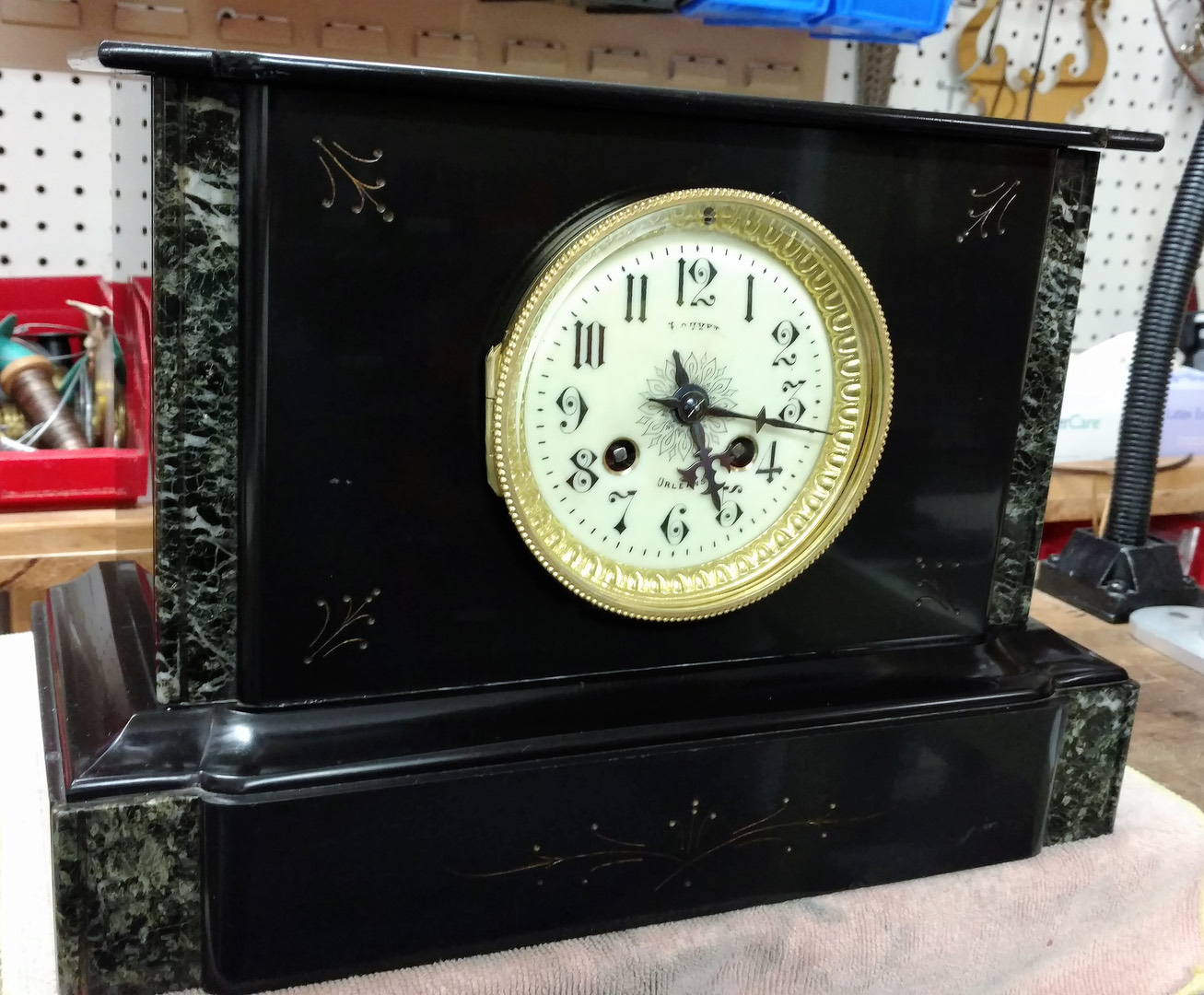 A restored slate and marble mantel clock with an ornate case