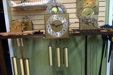 A row of restored grandfather clock dials and cases in the Gesswein's showroom